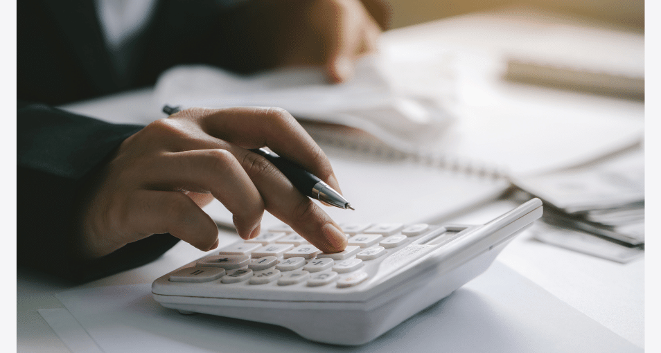 Personne utilisant une calculatrice pour calculer et déclarer ses revenus issus du trading