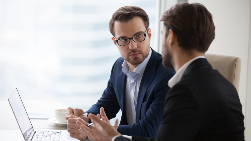 Un groupe d'hommes assis à une table en train de parler